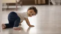 Cute Little African American Baby Toddler Crawl Make First Steps On Home Wooden Floor